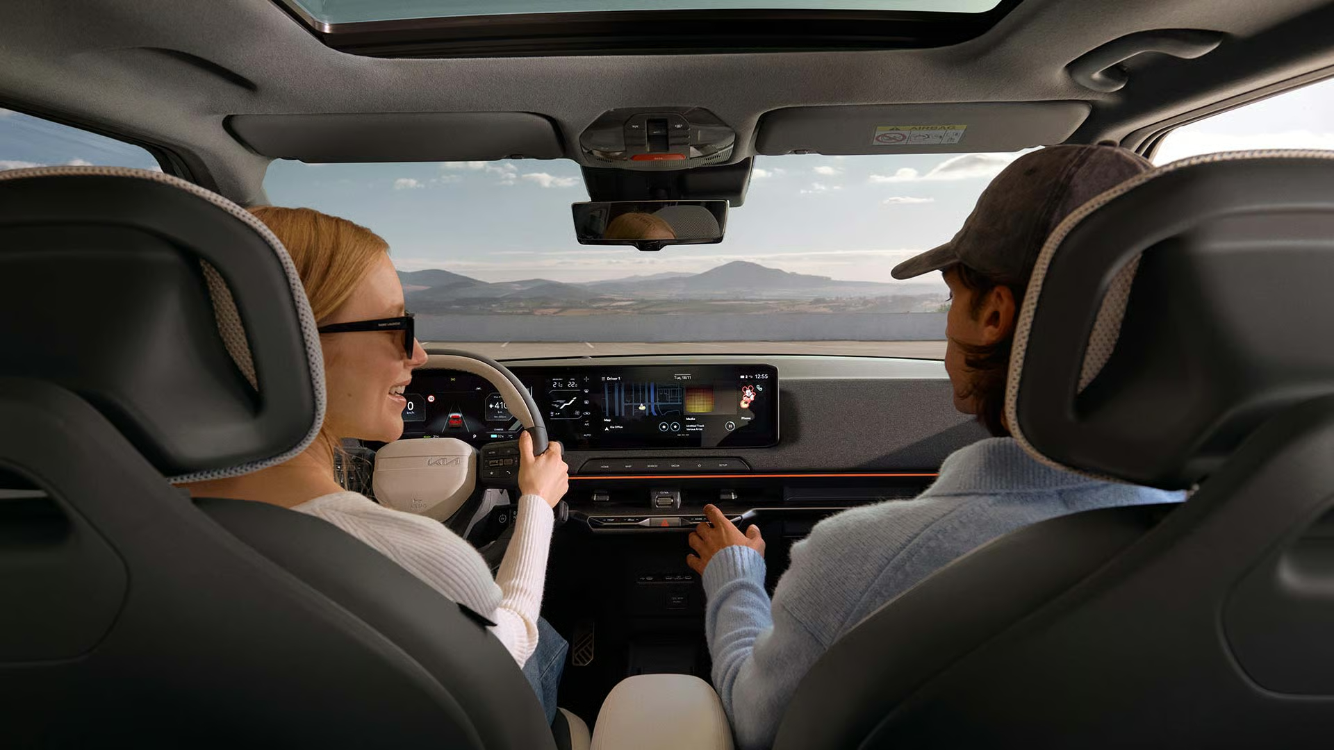 Kia EV2 Innenraum Infotainment und Menschen am Steuer